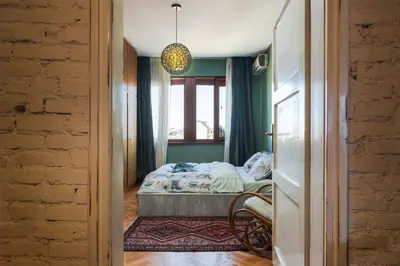a bedroom with a bed and a window at ART-ament, a unique central flat in Sofia