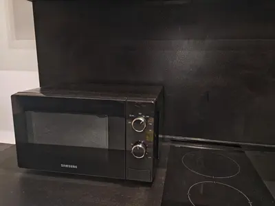 a black microwave sitting on top of a counter at Apartament 87 in Sofia