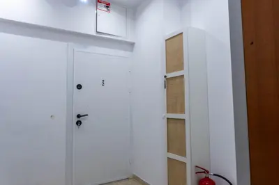 a white bathroom with a shower and a door at Apartament 87 in Sofia