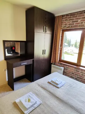 a bedroom with a bed and a desk and a window at Panorama Stoykite Belvedere in Stoykite