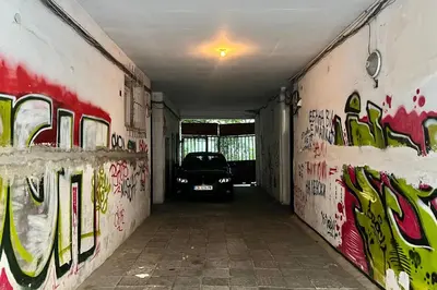 a car parked in a garage with graffiti on the walls at Nostalgic '90s Place Historical Center in Sofia