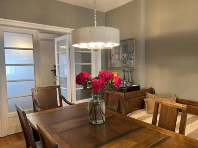 a dining room with a table with flowers in a vase at Laurel & Hardy - Old city center Apart in Sofia