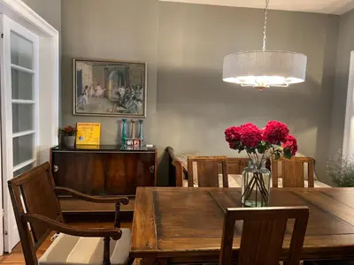 a dining room with a table with a vase of red flowers at Laurel & Hardy - Old city center Apart in Sofia