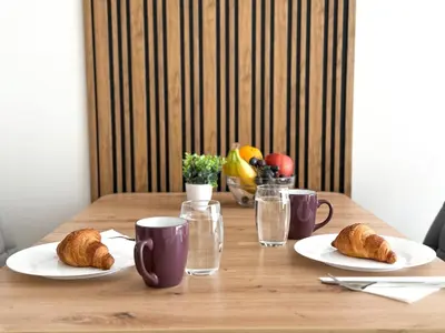 a wooden table with two plates of croissants and glasses at Modern 1BR Apartment with Free Street Parking and free Gym Pass in Plovdiv