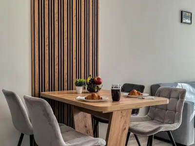 a wooden table with two plates of food and chairs at Modern 1BR Apartment with Free Street Parking and free Gym Pass in Plovdiv