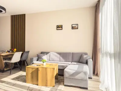 a living room with a couch and a table at Modern 1BR Apartment with Free Street Parking and free Gym Pass in Plovdiv