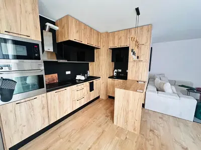a kitchen with wooden cabinets and a couch in a room at Raya apartment in Plovdiv