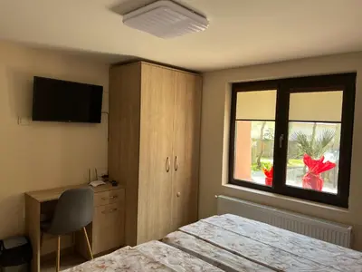 a bedroom with a bed and a window and a desk at Къща за гости Бадови in Hisarya
