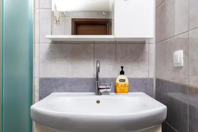 a bathroom sink with a bottle of soap on it at Modern and Cozy 1BD in the Top Centre of Plovdiv by Flat Mаnager in Plovdiv