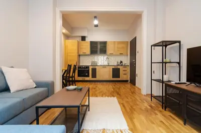 a living room with a blue couch and a kitchen at Modern design 1 bdrm, 4 guests, Top cente, Near Parliament, Self check-in in Sofia