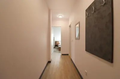a hallway with white walls and a large painting on the wall at New Sofia Skyline 1BDRM Free Parking & Terrace in Sofia