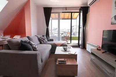 a living room with a couch and a tv at New Sofia Skyline 1BDRM Free Parking & Terrace in Sofia