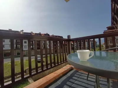 a coffee cup sitting on a table on a balcony at Студио в хотел Мария Антоанета in Bansko