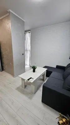 a living room with a couch and a coffee table at Апартаменти за гости Кедър in Sapareva Banya