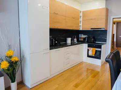 a kitchen with white cabinets and a vase of flowers at City Center Spacious 2BR near Vitosha Blvd in Sofia