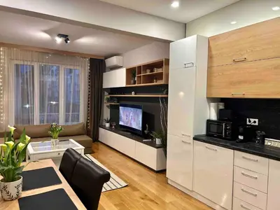 a living room with a table and a kitchen at City Center Spacious 2BR near Vitosha Blvd in Sofia