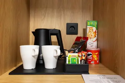 a coffee maker and two white cups on a shelf at AMAR Design Hotel by HMG in Sofia