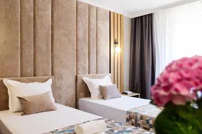 two beds in a hotel room with pink flowers at AMAR Design Hotel by HMG in Sofia