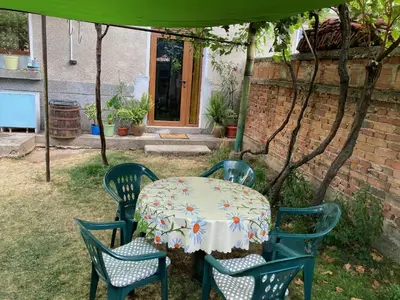 a table and four chairs with a white tablecloth on it at Garden apartment in Karlovo
