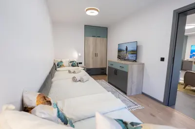 a living room with a couch and a tv at Arni Aparts in Velingrad