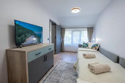 a living room with two beds and a flat screen tv at Arni Aparts in Velingrad