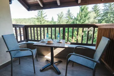 a table and two chairs on a porch with a view at Arni Aparts in Velingrad