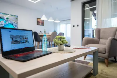 a laptop computer sitting on a table in a living room at Arni Aparts in Velingrad