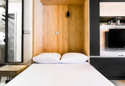 a bedroom with a white bed with a wooden headboard at Compact Studio for Digital Nomads, Fast WiFi, AC in Sofia