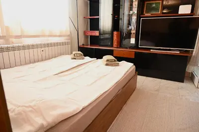 a large bed in a room with a television at Urban Oasis Studio in Sofia