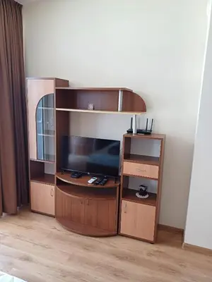 a entertainment center with a flat screen tv in a room at Апартамент - Студио Престиж 3 in Hisarya