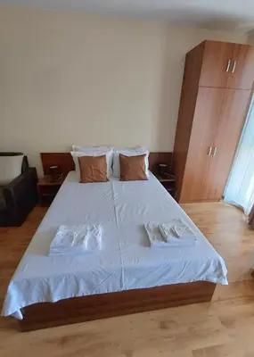a bedroom with a large bed with white sheets and pillows at Апартамент - Студио Престиж 3 in Hisarya