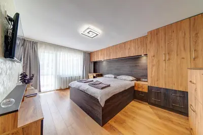 a bedroom with a large bed and wooden walls at Rhodope Escape - Modern 1BR Apartment with Balcony & Free Parking in Smolyan