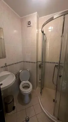 a bathroom with a shower and a toilet and a sink at Апартаменти Хармония in Pamporovo