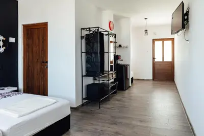 a bedroom with a bed and a wooden floor at Къщи БРИК вила 2 in Sapareva Banya