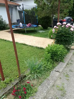 a garden with flowers and a picnic table in a yard at By the River Hotel Complex in Balkanets