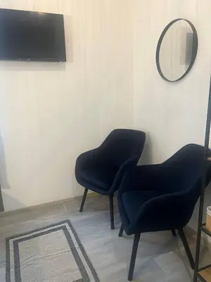 two blue chairs in a room with a mirror at Pirotska Cozy Room in Sofia
