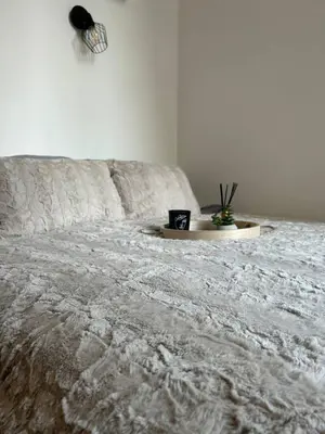 a white bed with a table on top of it at Pirotska Cozy Room in Sofia