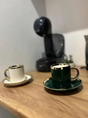 two coffee cups sitting on a wooden table at Pirotska Cozy Room in Sofia