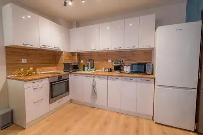 a kitchen with white cabinets and a refrigerator at Top Center Retreat, Near AUBG FREE Parking in Blagoevgrad