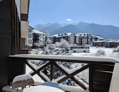 a snow covered balcony with a view of a city at Aspen Apartment A212 3OOm from Gondola in Bansko