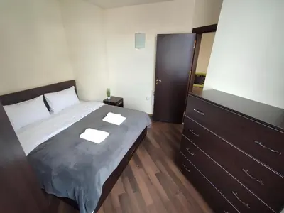 a bedroom with a large bed and a dresser at Aspen Apartment A212 3OOm from Gondola in Bansko