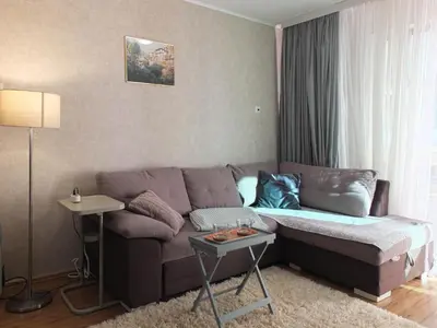 a living room with a couch and a table at The snug apartment near the brimming mountains in Bansko