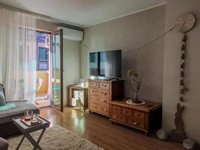 a living room with a tv and a dresser with a tvicterictericter at The snug apartment near the brimming mountains in Bansko