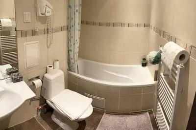a bathroom with a tub and a toilet and a sink at The snug apartment near the brimming mountains in Bansko