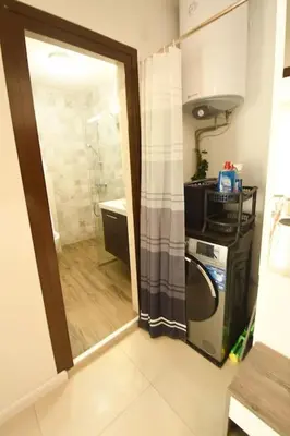 a bathroom with a shower and a washer and dryer at INB Banishora Spot in Sofia