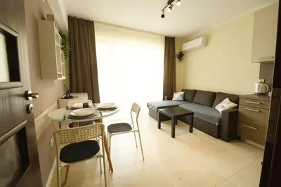 a living room with a couch and a table and chairs at INB Banishora Spot in Sofia