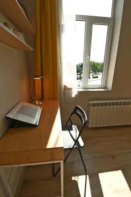 a laptop computer sitting on a wooden desk with a window at Eagle's Spot in Sofia