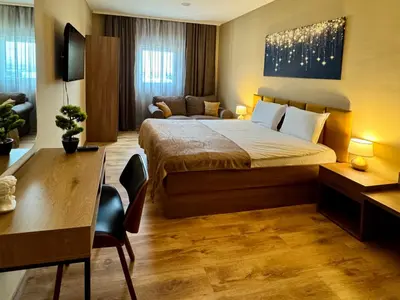 a bedroom with a bed and a desk and a couch at Apartments Sofia Airport free shuttle and parking in Sofia