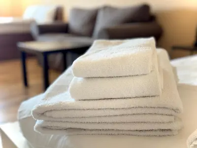 a stack of white towels sitting on a table at Apartments Sofia Airport free shuttle and parking in Sofia