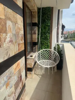 a white chair on a balcony with a swing at Anna Lux in Bansko